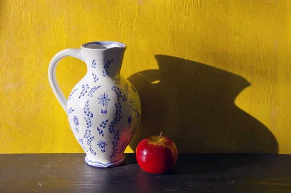 Натюрморт с белым кувшином и красным яблоком — стоковое фото