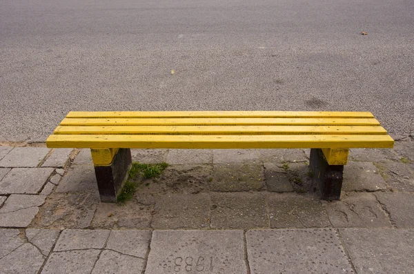 Пустая желтая скамейка на улице — стоковое фото