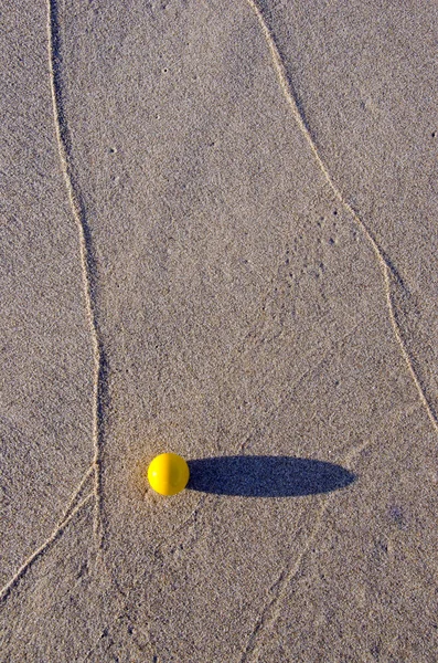 Bola amarela na areia praia do mar — Fotografia de Stock