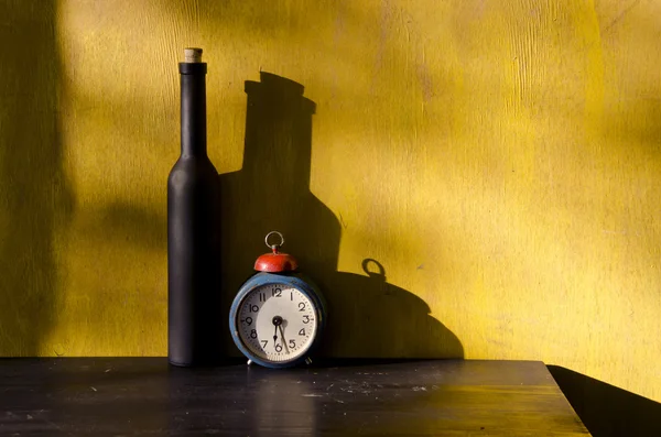 Vida útil com garrafa preta e relógio velho — Fotografia de Stock