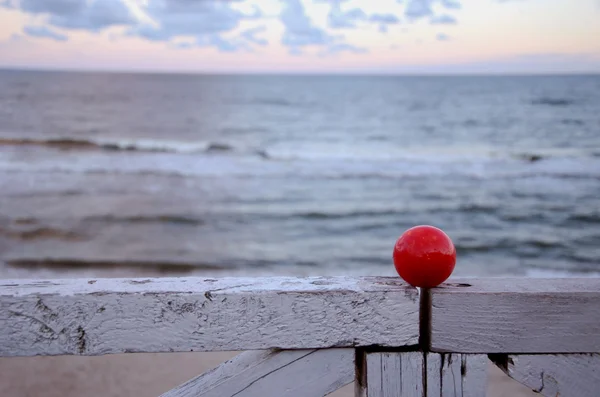 Balle rouge sur la clôture et la mer — Photo