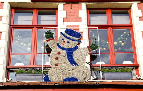 Snowman on the old town window — Stock Photo, Image
