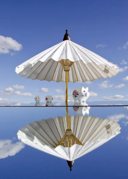 Piggybanks på spegeln och paraply — Stockfoto
