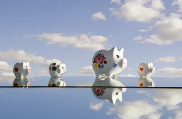 Piggybanks op de spiegel en hemel — Stockfoto