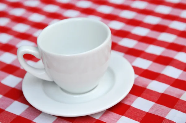 stock image White ceramic empty Cup whit checkered tavlecloth