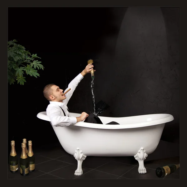 stock image Мужчина в ванной с шампанским