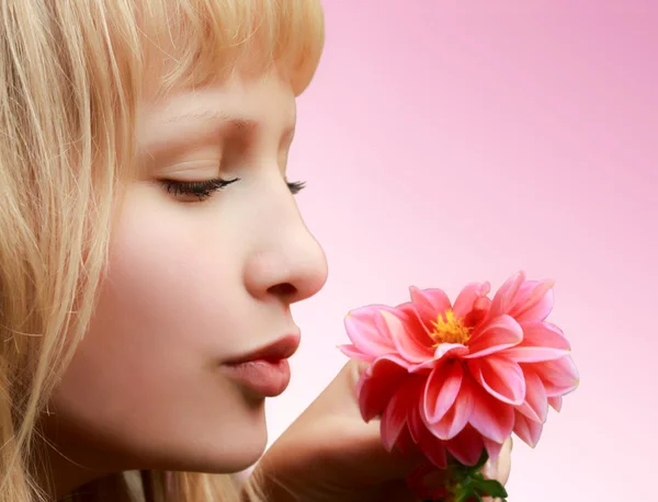 Bella ragazza con fiore su sfondo rosa — Foto Stock