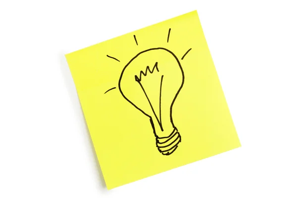 電球のイメージと紙の黄色シート — ストック写真