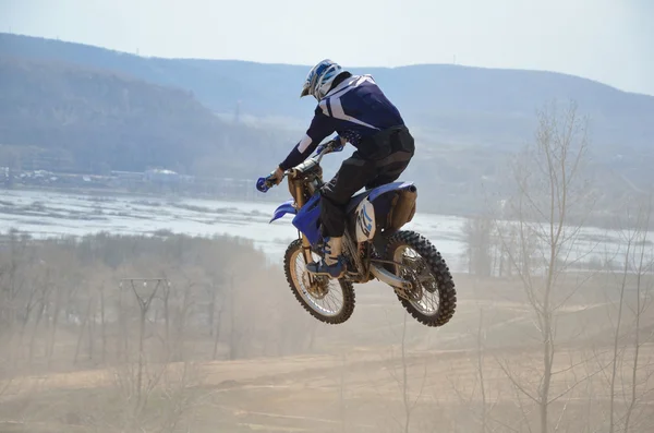Motocross rider en una moto salta desde una gran montaña —  Fotos de Stock