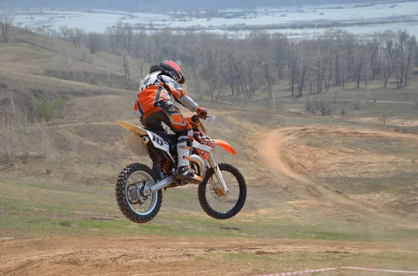Motocross piloto em uma moto salta de uma grande montanha — Fotografia de Stock