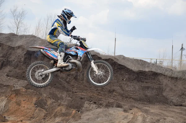 Motocross rider jumps over an earthen pit with one hand — Stock Photo, Image