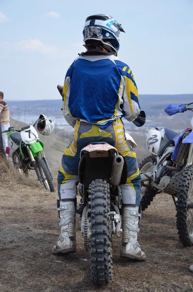 Motorcross rijder in de helm zit op een motorfiets — Stockfoto