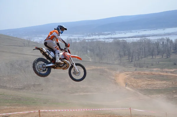 Motocross piloto em uma moto salta de uma grande montanha — Fotografia de Stock
