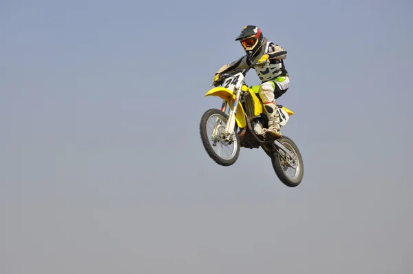 Motocross moto coureur effectue un saut efficace — Photo