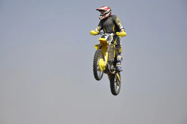 Salta sobre un alto montículo de tierra en la moto — Foto de Stock