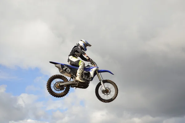 Een sprong over de heuvel, motorcoureur op een motorfiets — Stockfoto