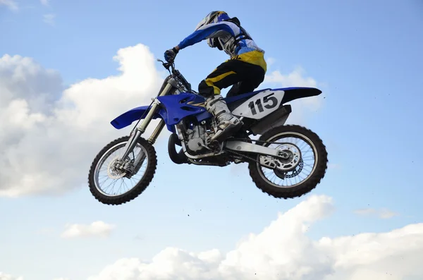 Motocross yarışçısı bir motosiklet üzerinde yüksek uçuş — Stok fotoğraf