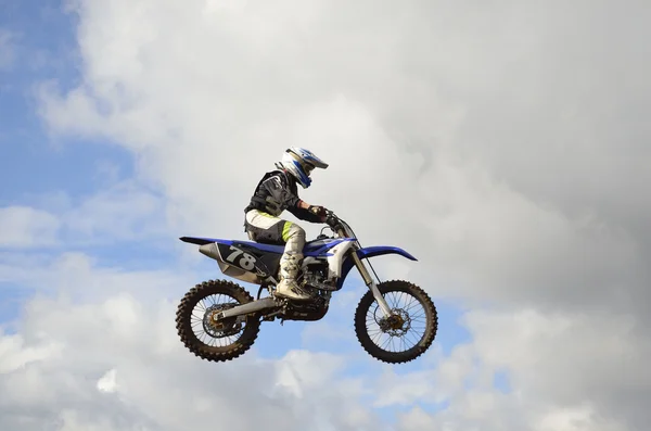 Een sprong over de heuvel motorcrosser — Stockfoto