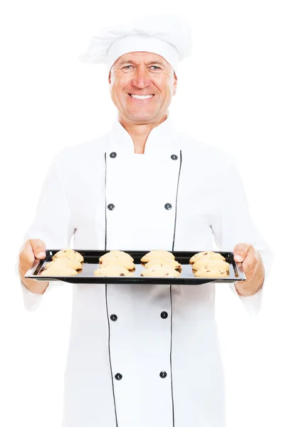 Cozinheiro sorridente segurando assadeira com biscoitos — Fotografia de Stock