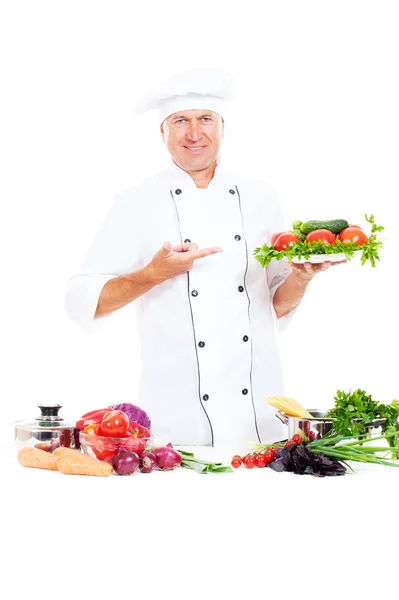Chef pointing at plate with fresh vegetables — Stock Photo, Image