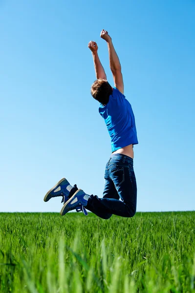 Man springen op het groene veld — Stockfoto