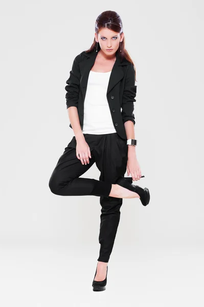Sexy vrouw in zwarte jas poseren — Stockfoto