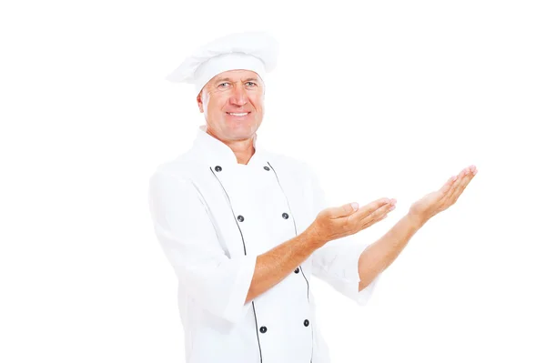 Sorridente anziano cuoco mostrando qualcosa — Foto Stock