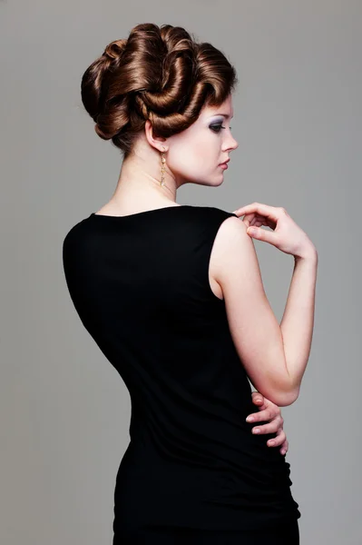 Woman in black dress with hairdo — Stockfoto
