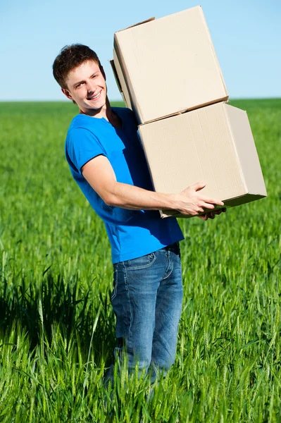 Man in blue t-shirt carrying boxes — Stock Photo, Image