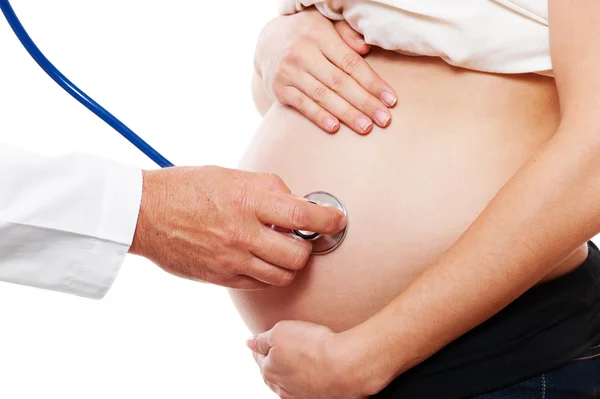Médico atentamente ouvir barriga da mulher grávida — Fotografia de Stock