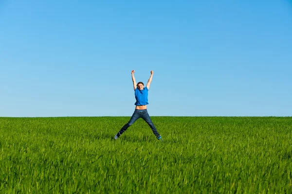 Man springen op het groene veld — Stockfoto