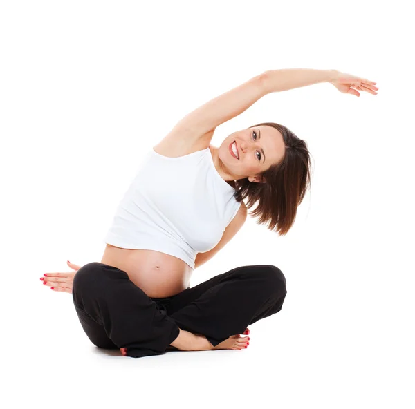 Mujer embarazada haciendo gimnasia de estiramiento — Stok fotoğraf