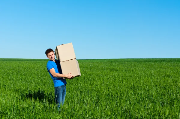 Messenger in blue t-shirt carrying boxes — Stock Photo, Image