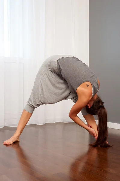 Mulher fazendo exercício de flexibilidade no quarto — Fotografia de Stock