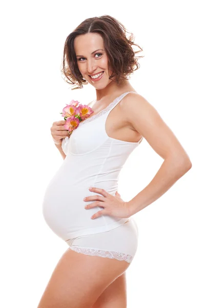 Красивая беременная с цветами — стоковое фото