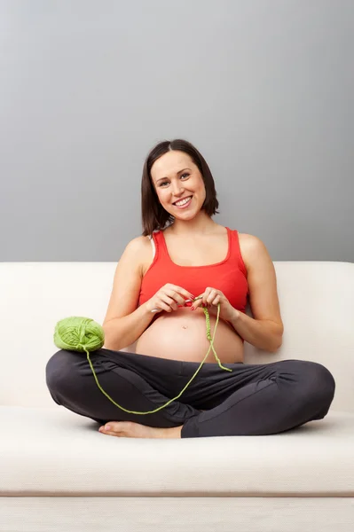 Glückliche Schwangere häkelt — Stockfoto