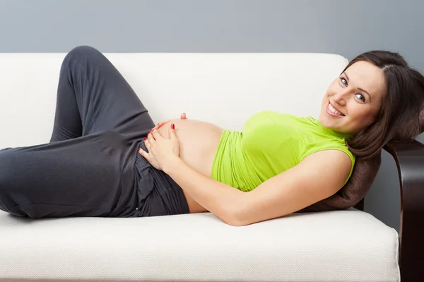 怀孕的女人躺在沙发上 — 图库照片