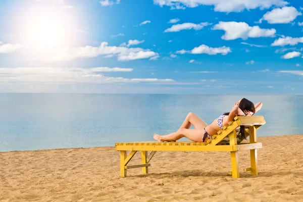 Jeune femme se détendre sur la plage — Photo