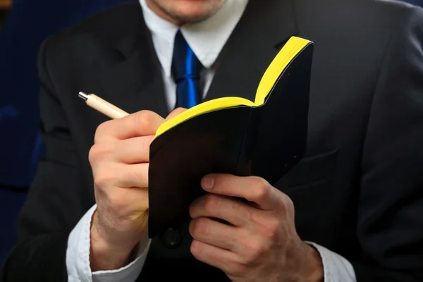Affärsman håller sin anteckningsbok — Stockfoto