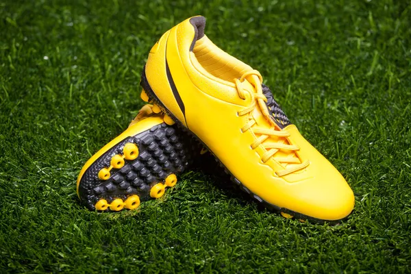 Pair of soccer shoes on grass field — Stock Photo, Image