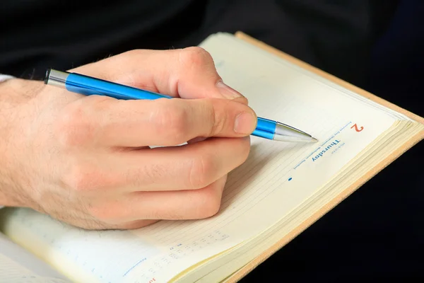 Hand and notebook. Close up Stock Picture