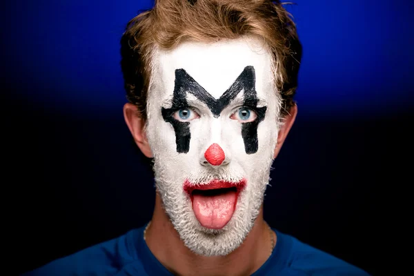 Een man met clown make-up op zijn gezicht — Stockfoto