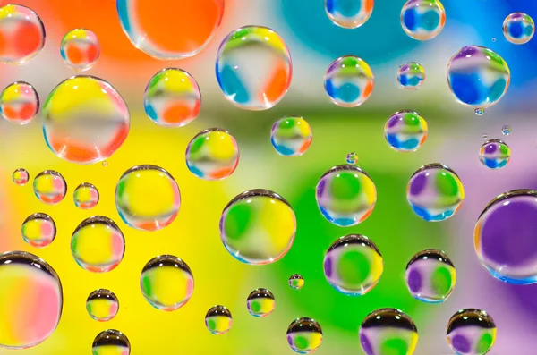 Gocce d'acqua su uno sfondo colorato . — Foto Stock