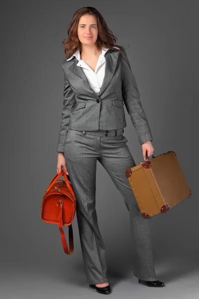 Uma mulher de negócios com um saco e uma mala. — Fotografia de Stock
