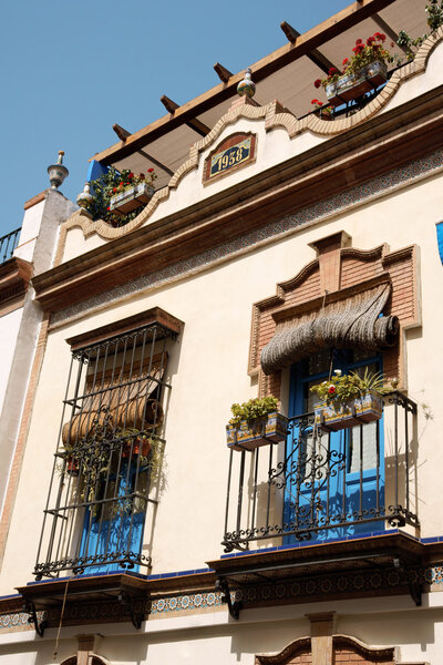 Typical house in Seville with balcony decorated with azulejos tiles. As shown in the upper part of the facade this habitation was constructed in 1938.