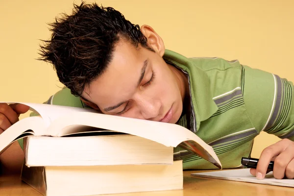Student sleeping on books