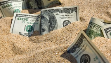 Dollars in sand on a beach clipart