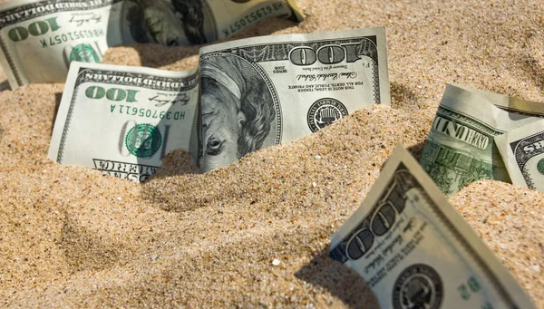 Долари в піску на пляжі — стокове фото