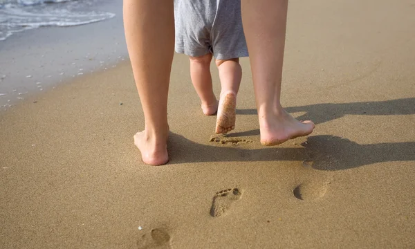 Mère et enfant marchant sur une plage de sable — Photo
