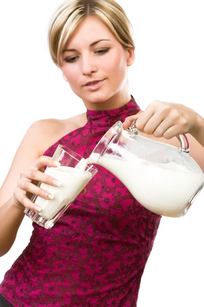 Mooie vrouw giet melk in glas — Stockfoto
